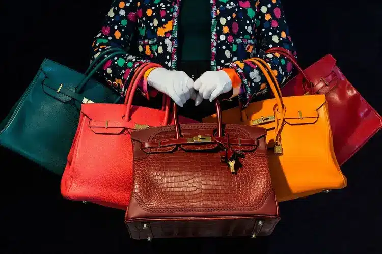 Multiple hermes bags, all different colors being carried together.