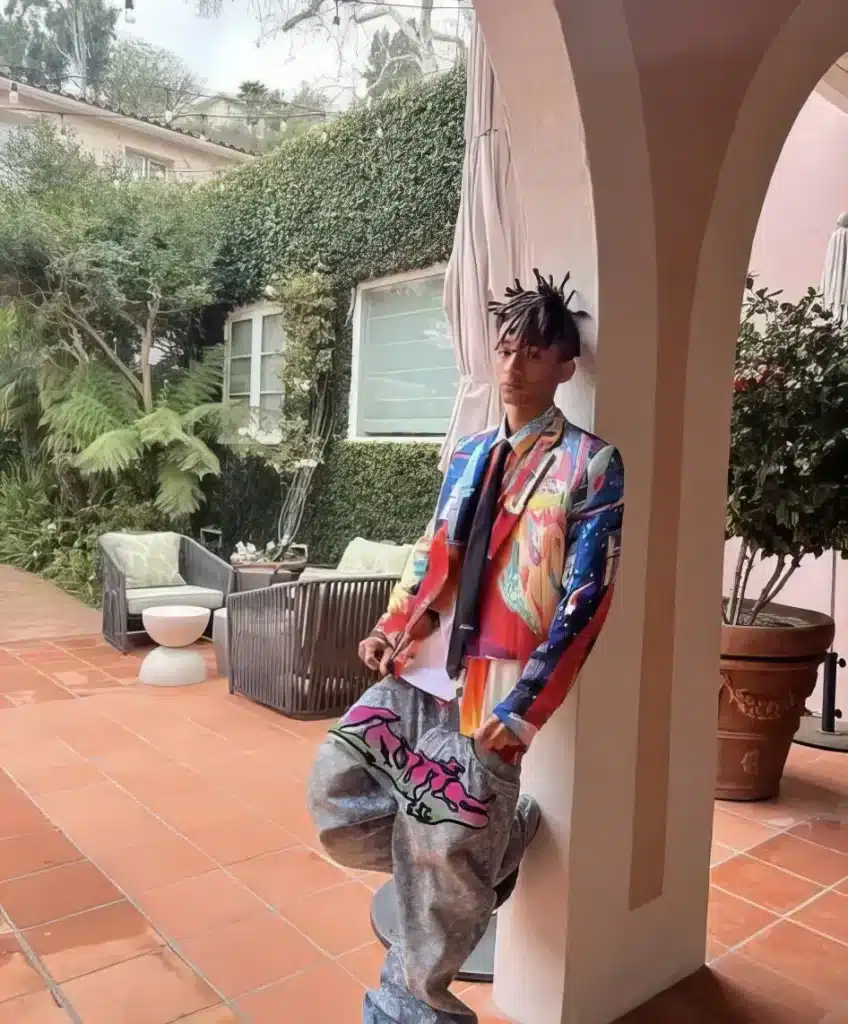 jaden wearing a multi colored suit jacket and blue louis vuitton denim pants