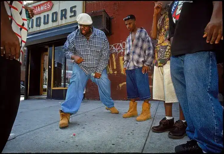 Notorious B.I.G rolling dice in 1994 wearing baggy blue denim and classic timbs