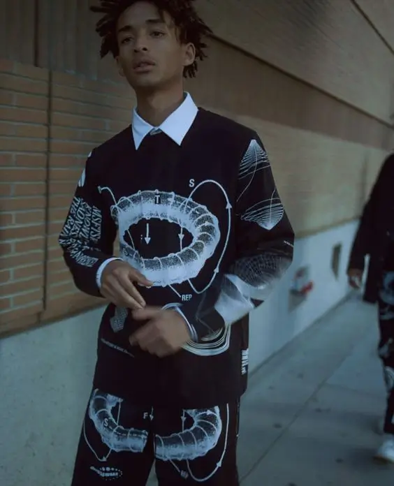 jaden wearing white shirt and black tie with matching black and white sweater vest and shorts