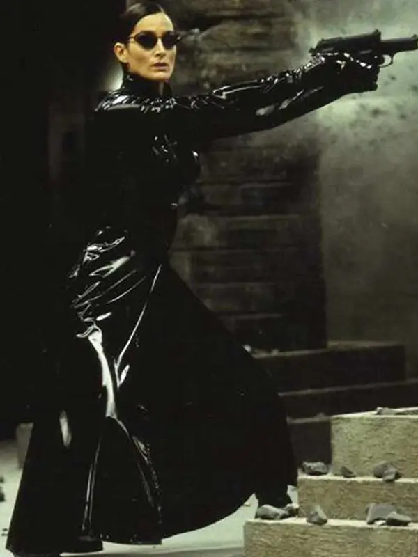 iconic image of trinity from the matrix pointing a gun while wearing her long leather trench coat