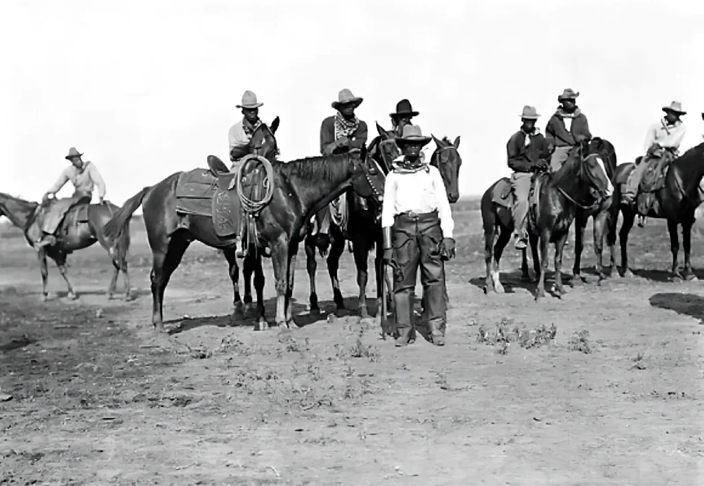 vintage black and white image of black cowboys on a field with their horses