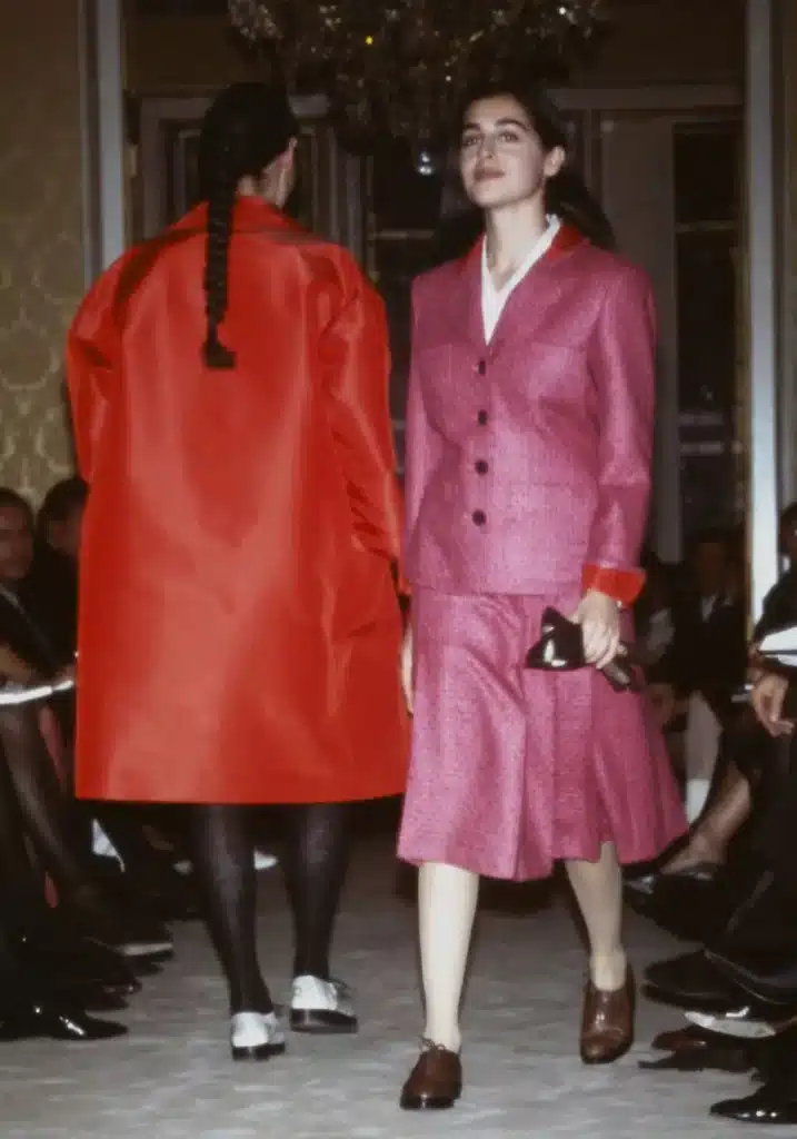 image of models walking down the runway for Miuccia Prada’s first ready-to-wear collection, FW 1988, with one wearing all pink suit