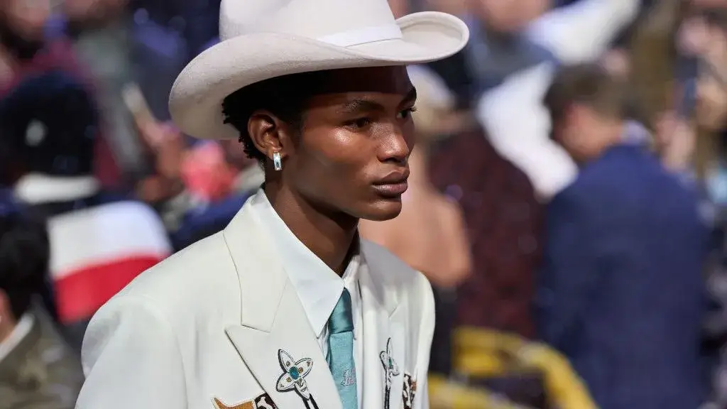 man wearing an all white western ensemble with a white cowboy hat