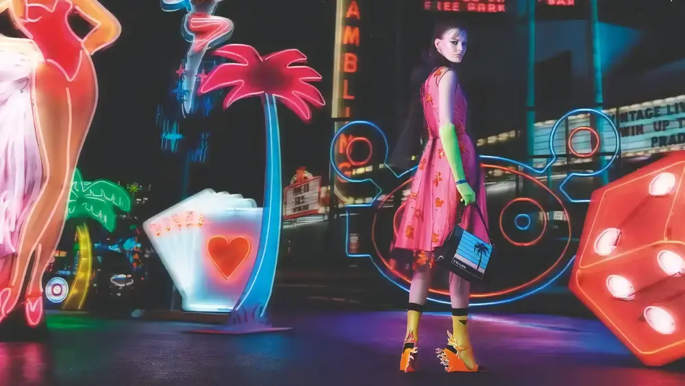 campaign image of the Prada fall/winter 2018, featuring a model holding a Prada piece against a background featuring multiple neon elements