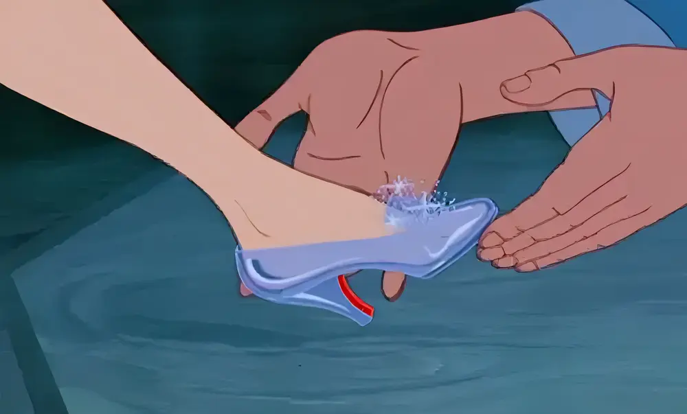 Animated scene of Cinderella's foot being fitted into the iconic glass slipper by the prince.