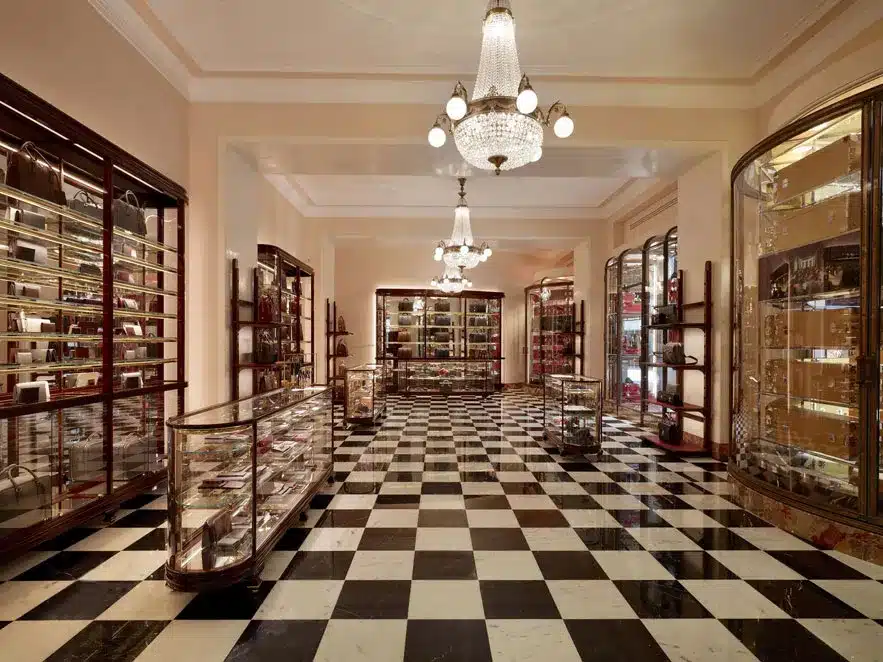 The luxurious Prada boutique located in the historic Galleria Vittorio Emanuele II in Milan, featuring elegant glass display cases, checkerboard marble floors, and ornate chandeliers, blending fashion and architectural elegance.