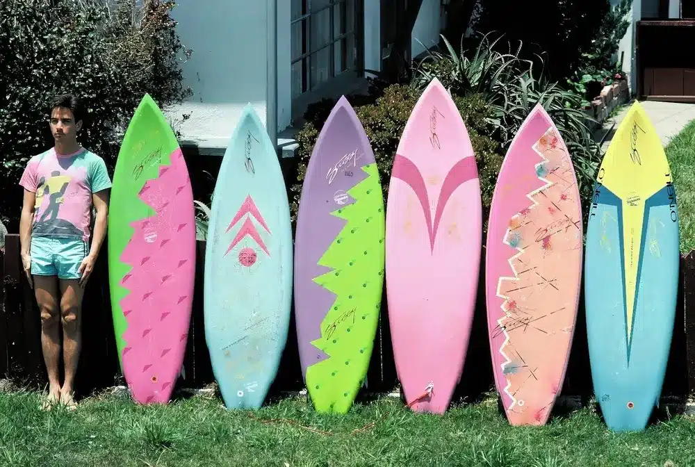 A vibrant collection of surfboards designed by Shawn Stüssy, featuring colorful and distinctive graphics, reflecting the brand's surf culture origins.