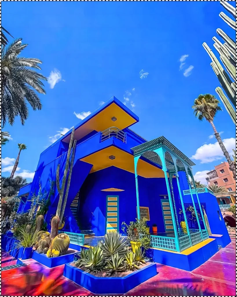 The iconic blue and yellow exterior of Yves Saint Laurent’s house in Marrakech, surrounded by lush gardens.